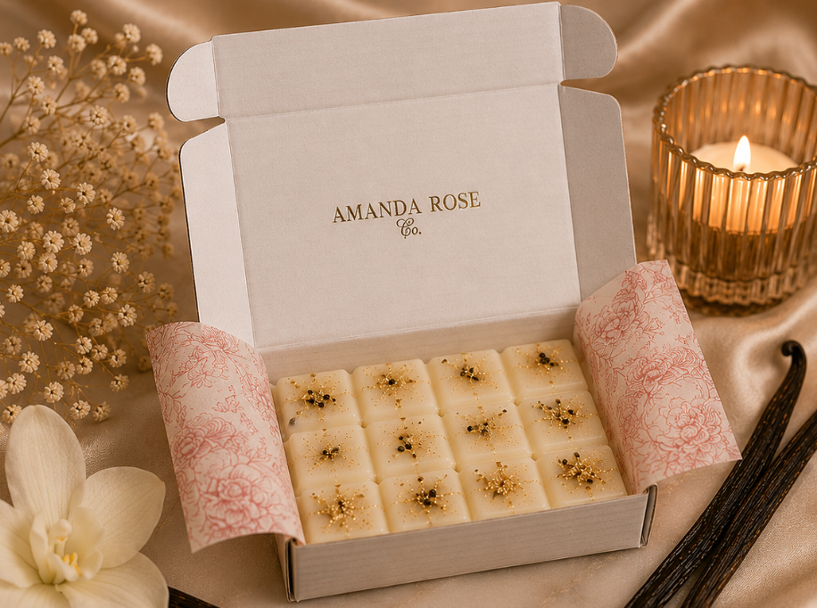 Box of Amanda Rose Co. candles with vanilla bean wax melts and a candle in the background