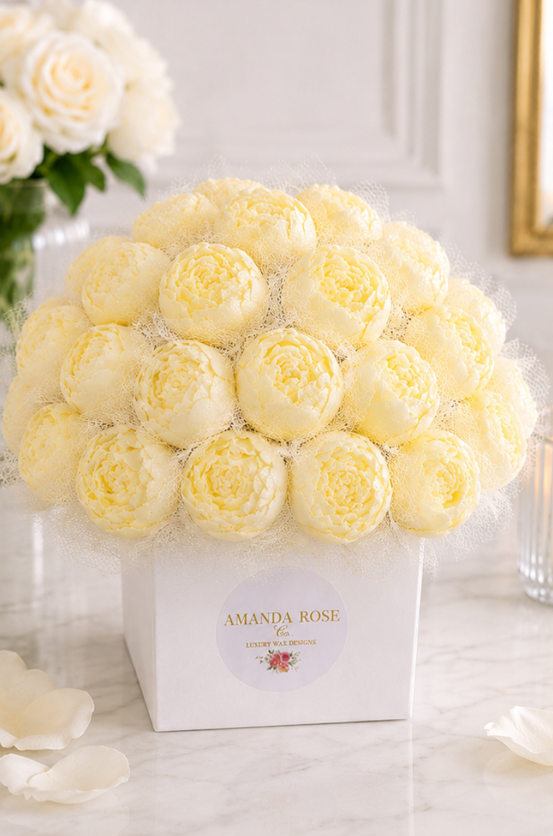 Bouquet of yellow roses in a box with 'Amanda Rose' branding on a marble surface.