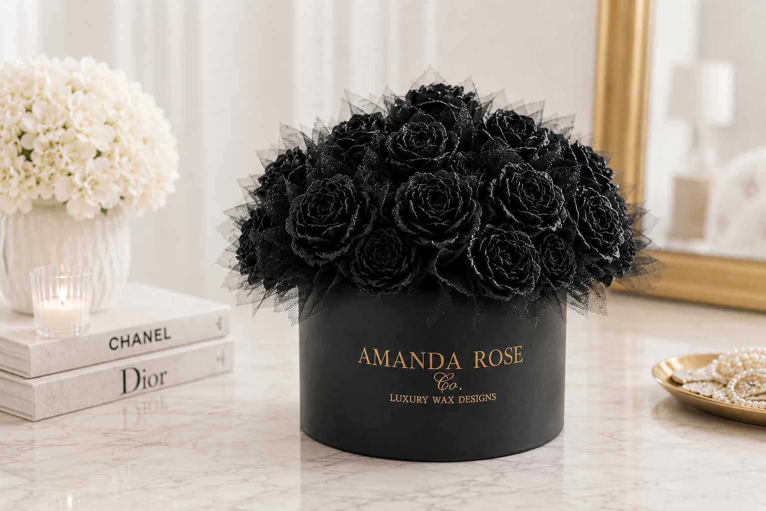 Black roses in a black box labeled 'Amanda Rose' on a table with candles and books.
