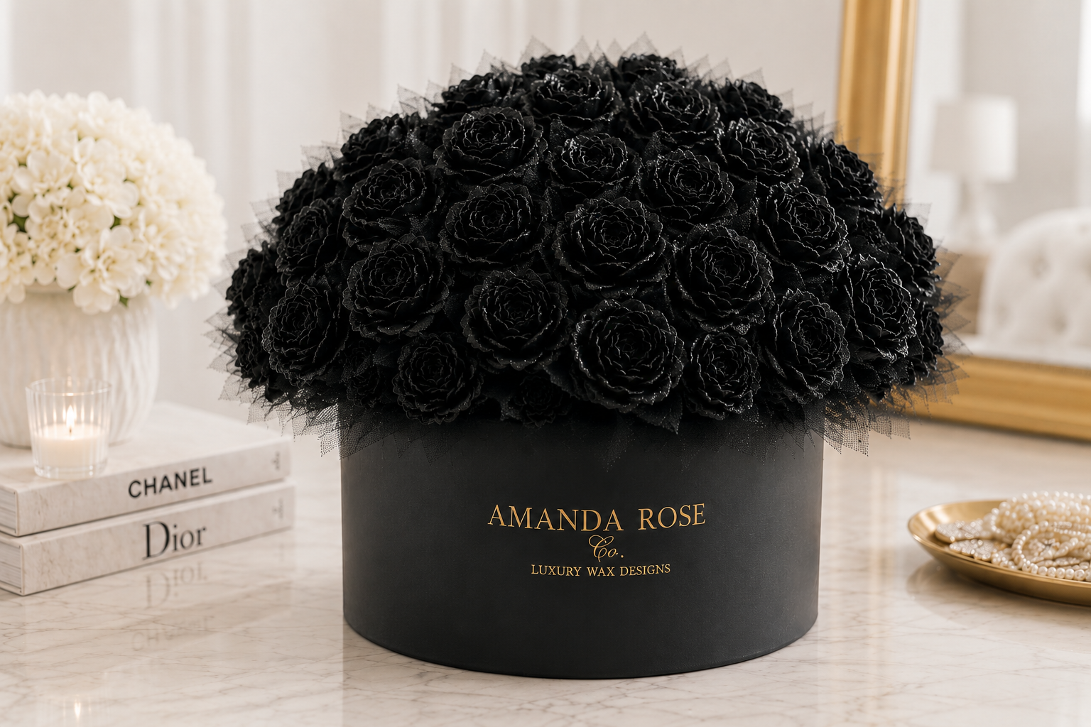 Black roses in a black box with 'Amanda Rose' branding on a decorative surface.