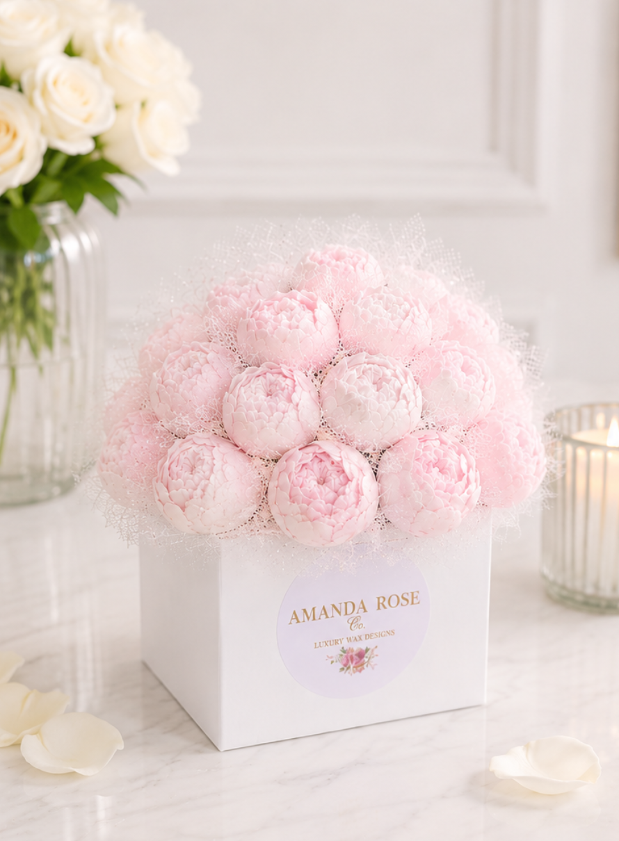 Pink and white peony arrangement in a white box with 'Amanda Rose' branding on a light background.