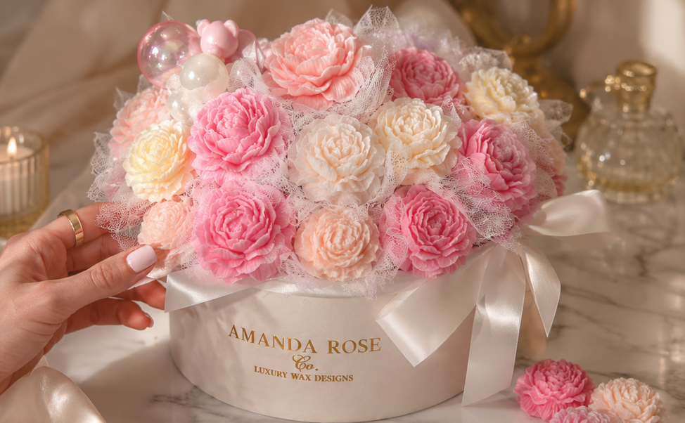 Floral arrangement in a box with 'Amanda Rose' branding on a decorative background.