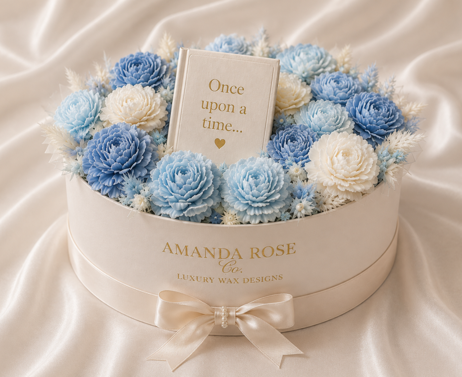 Round Gift box with baby blue wax flowers in round box with small book that says once upon a time in the middle. beautiful white ribbon around the gift box
