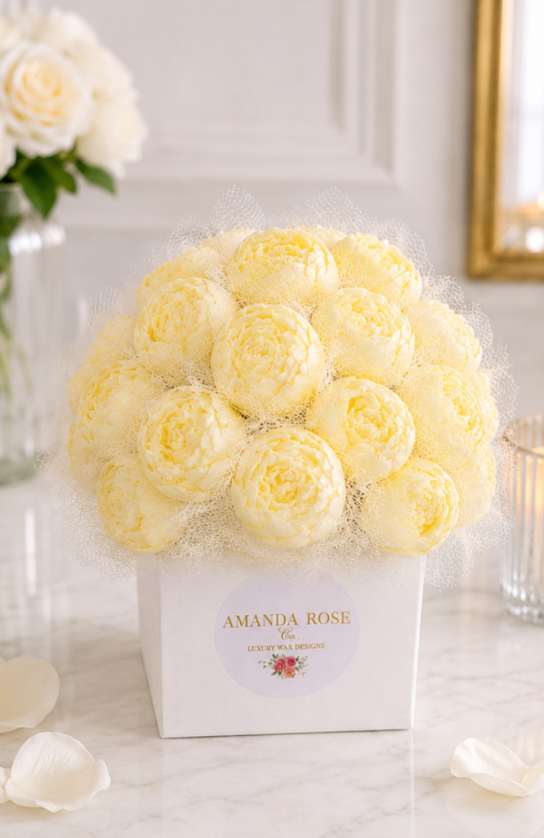 Bouquet of white roses in a box with 'Amanda Rose' branding on a marble surface.