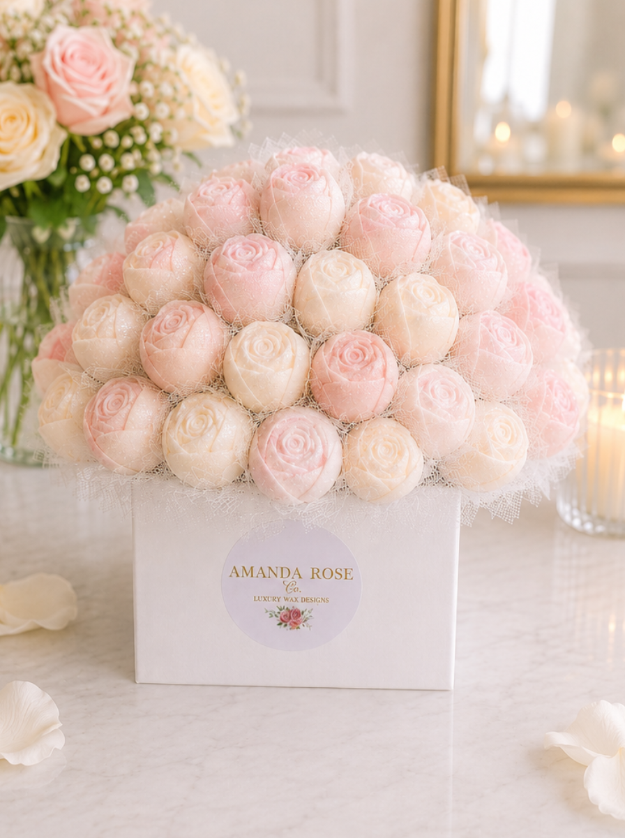 Bouquet of pink and white roses in a box with 'Amanda Rose' branding on a light background.
