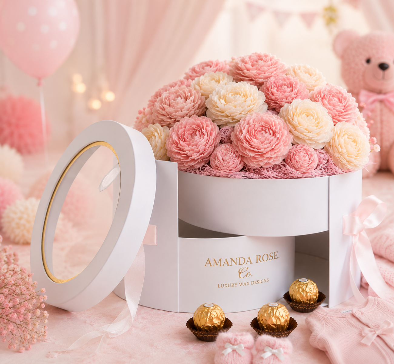 Floral arrangement in a white box with 'Amanda Rose Co.' branding, surrounded by pink and gold decorative elements.